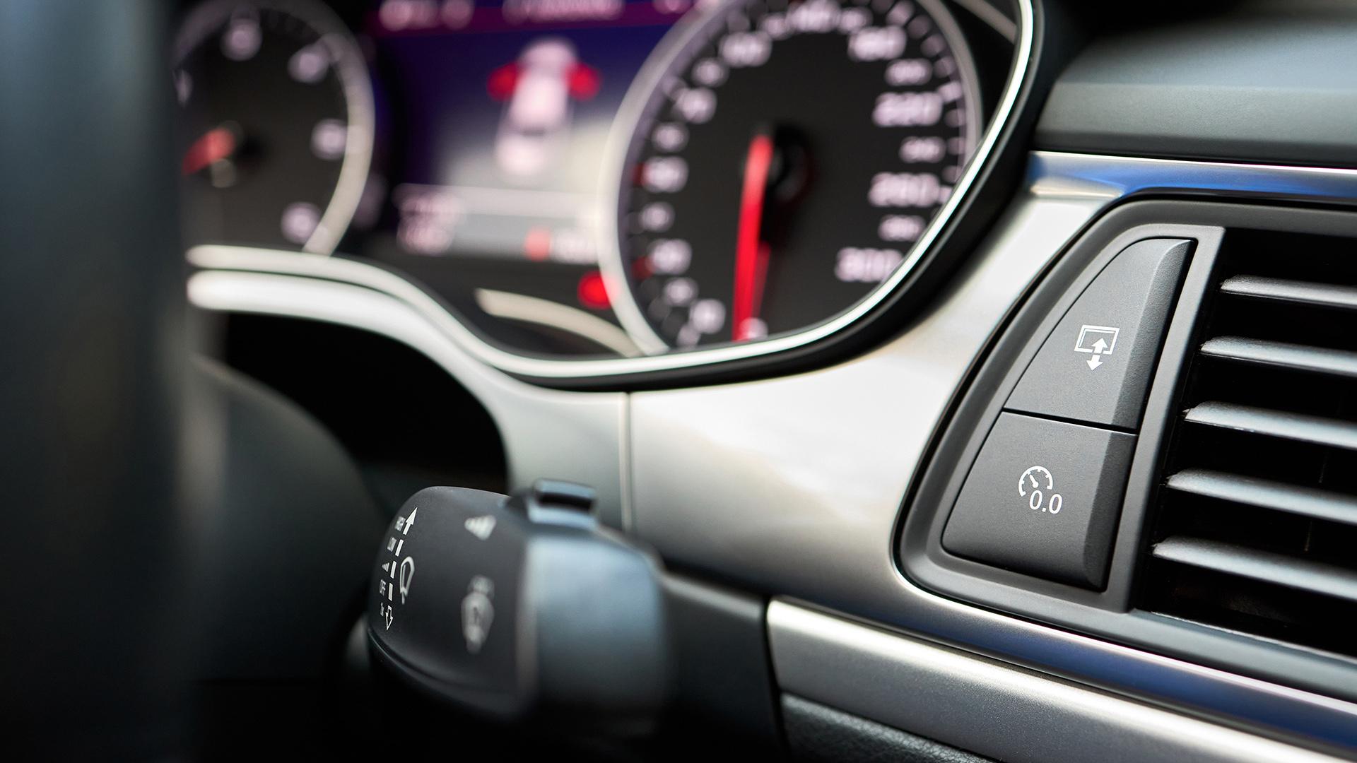 Modern luxury car interior Reset button for trip odometer or trip reset and Multimedia Interface display button selective focus with out of focus dashboard and steering wheel