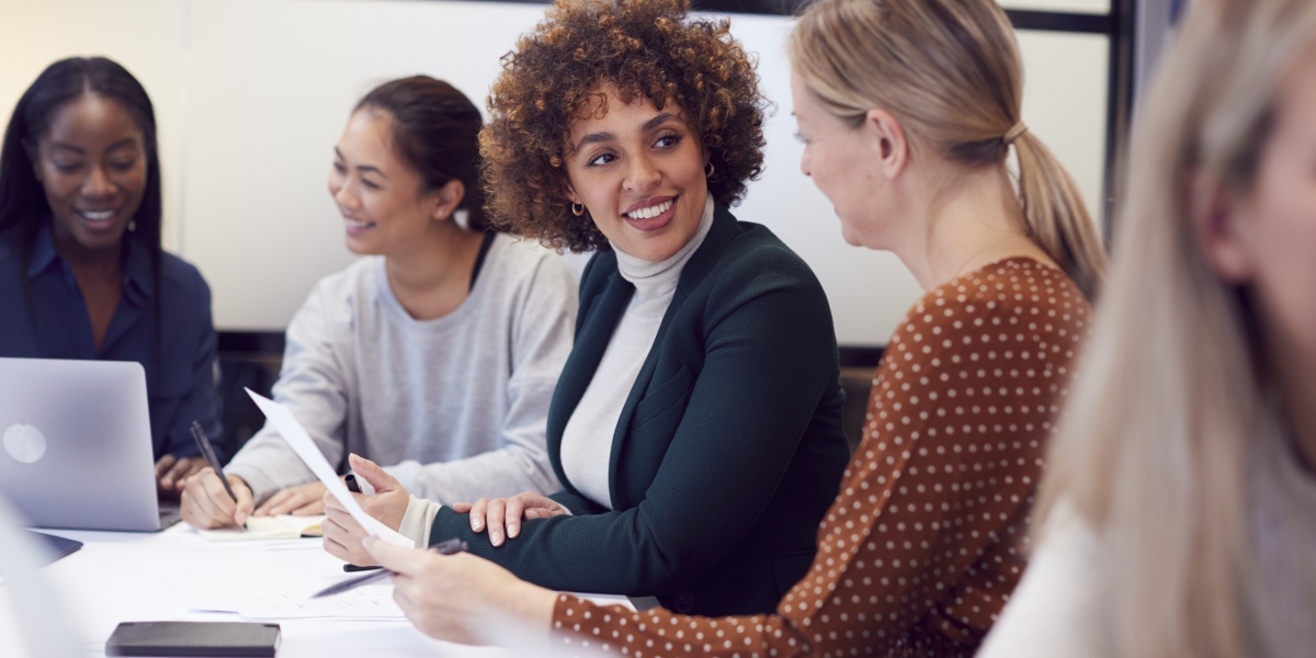 Group Of Businesswomen Collaborating In Creative Meeting Around Table In Modern Office 