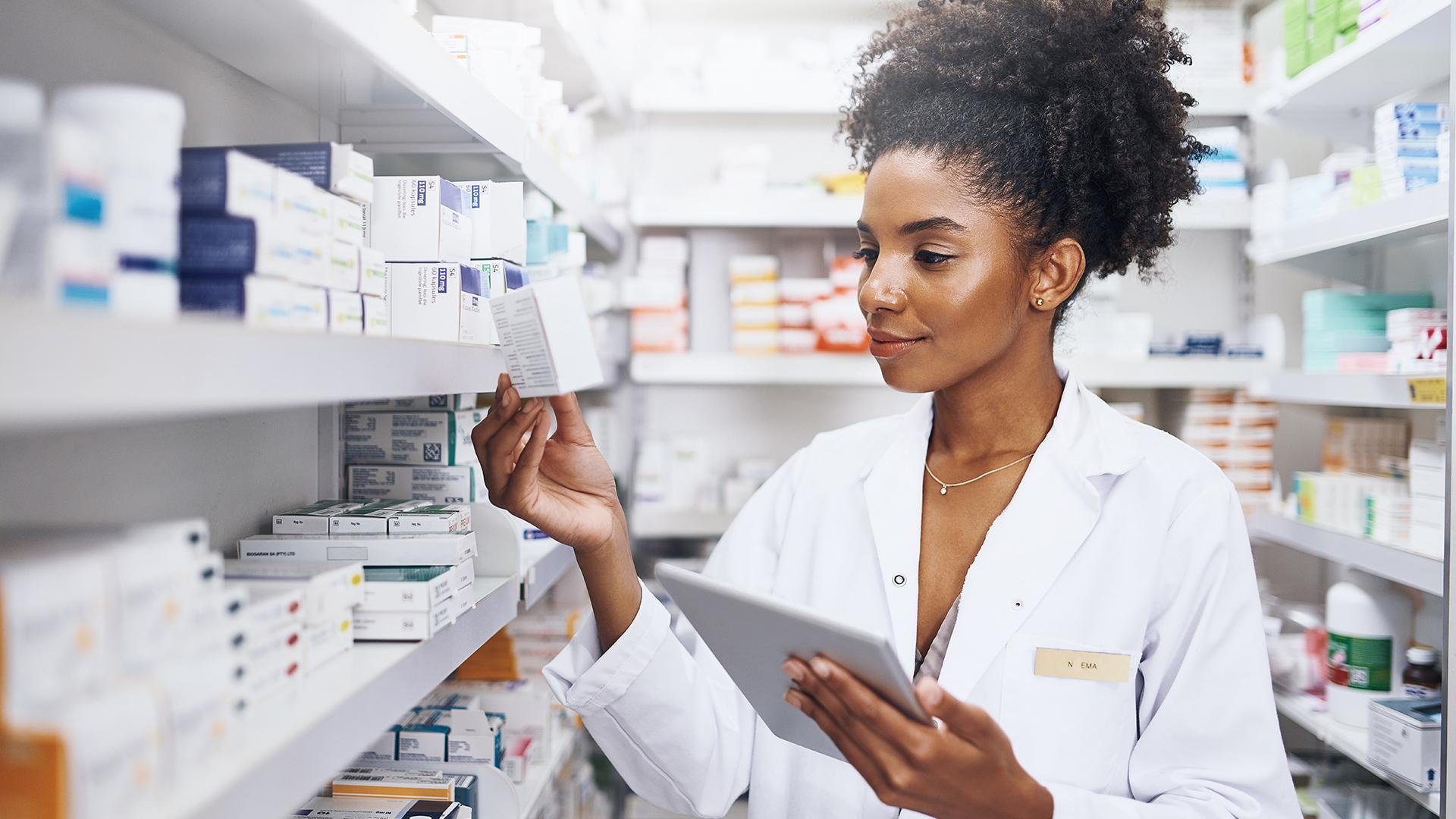 A pharmacist reading a prescription box in inventory